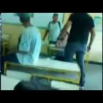 Professor pratica MMA com aluno em sala de aula